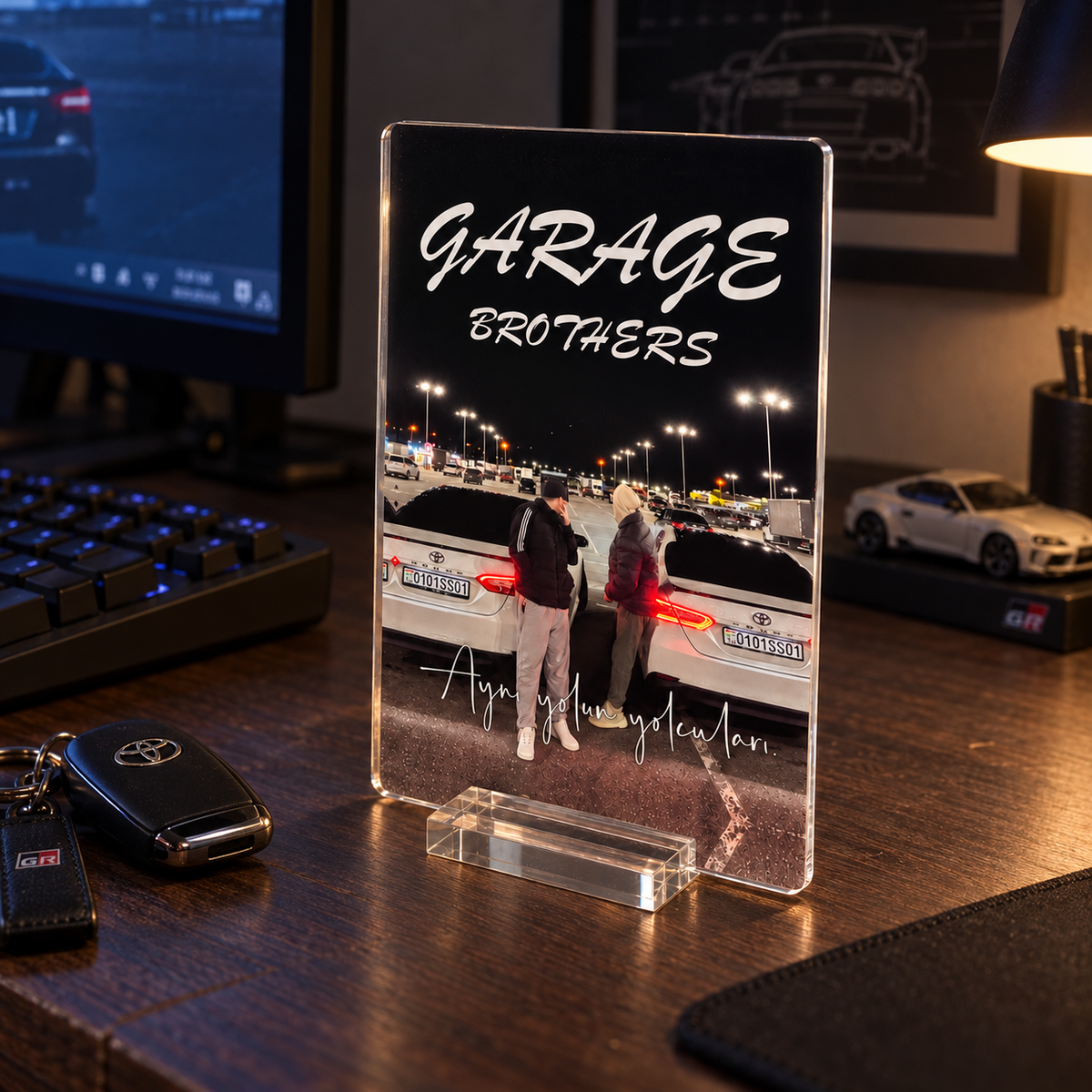 Garage Brothers Zarif standlı pleksi — loş bilgisayar odasında yan açı